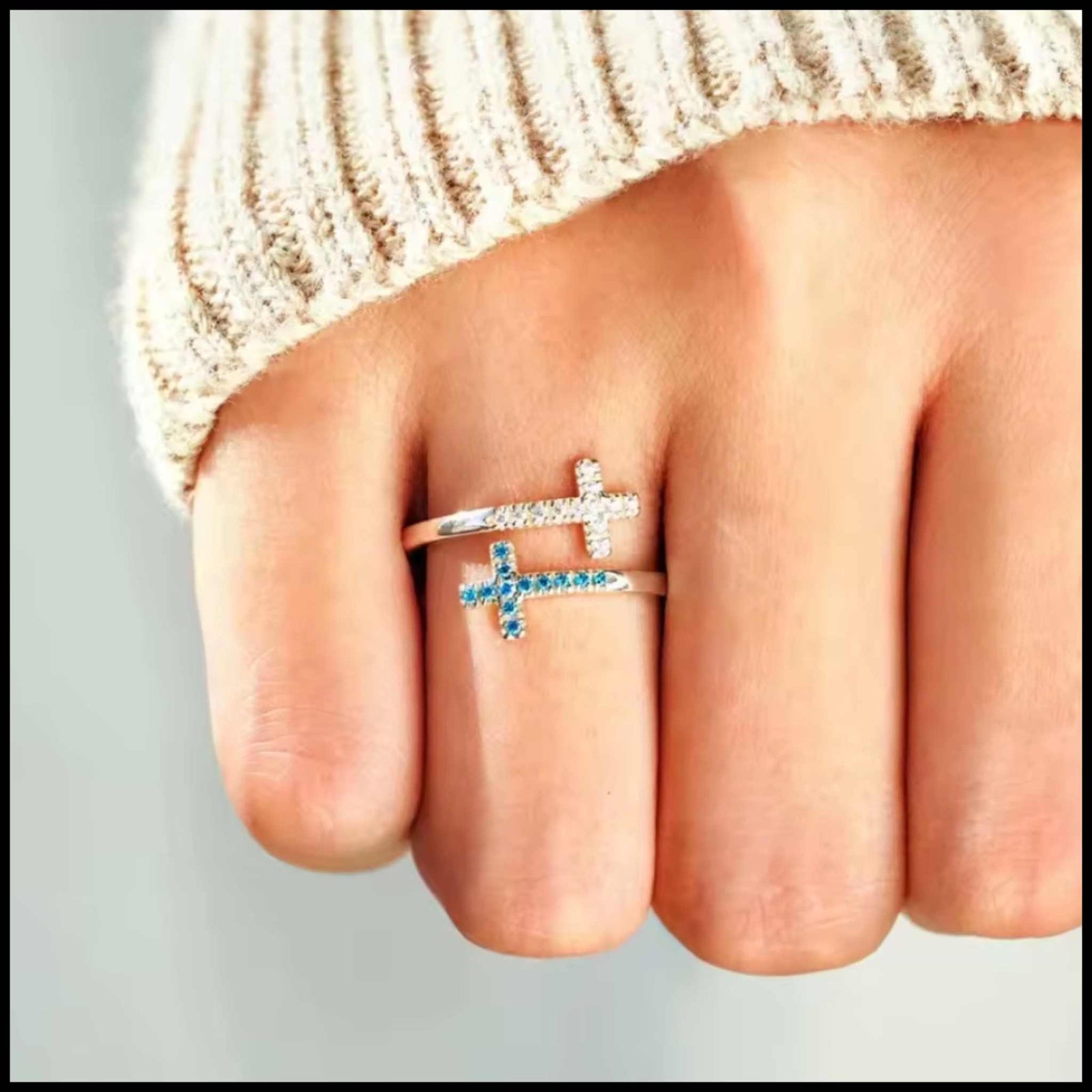 sterling silver adjustable ring with blue and white cubic zirconia cross designs on finger