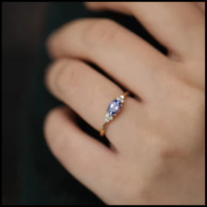 Blue Oval Stone Ring with gold-plated band and sparkling blue oval stone worn on finger