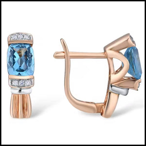 Rose gold earrings with blue gemstones on a white background