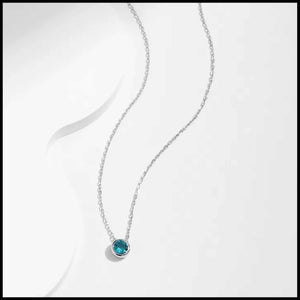Silver necklace with a blue gemstone pendant on a white background