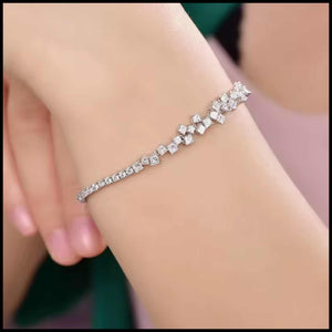 Diamond bracelet with clear stones on a wrist against a neutral background