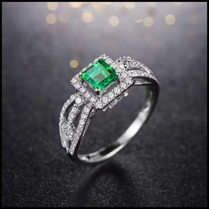 Emerald ring with diamonds on a dark background