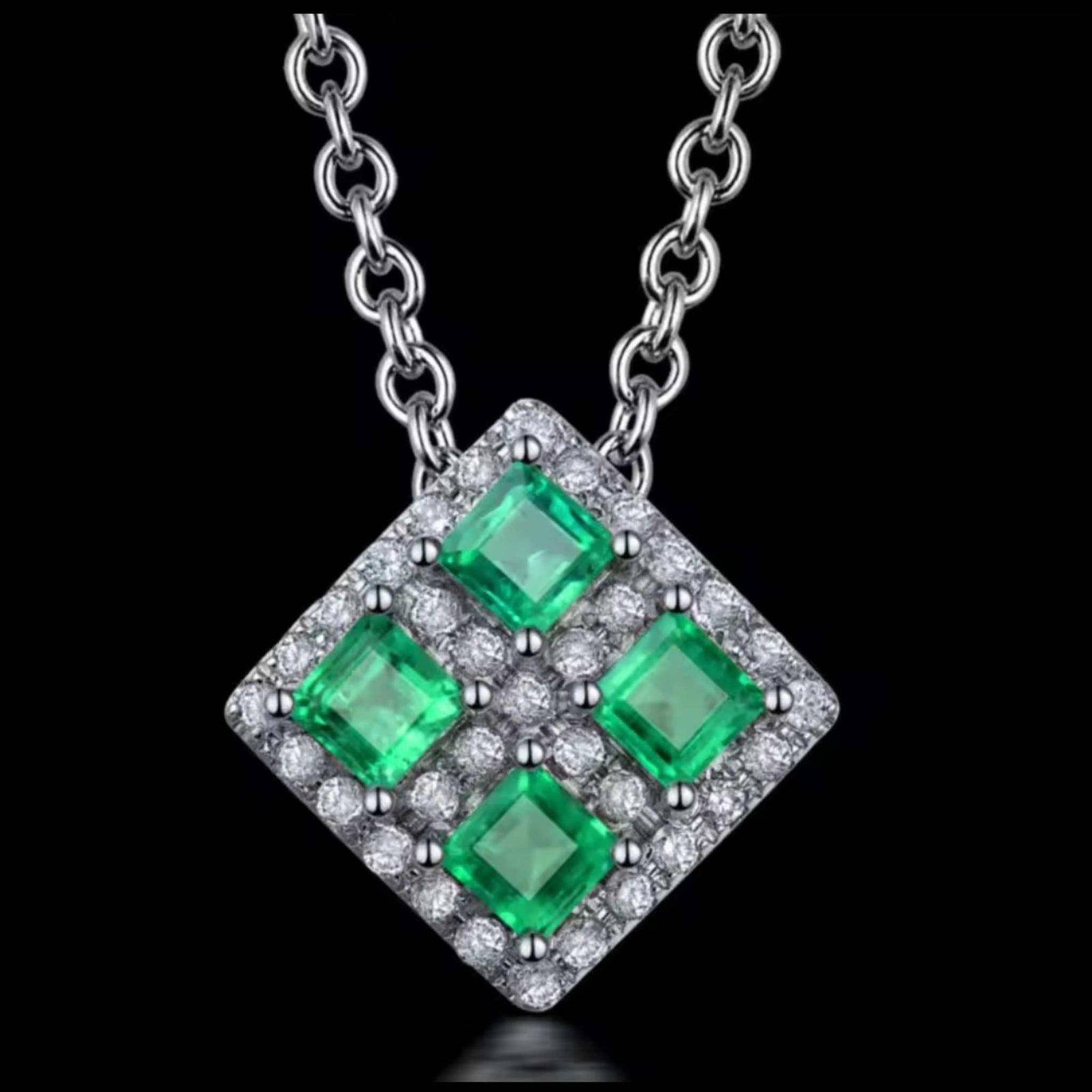 Princess cut emerald and diamond pendant with four green emeralds and surrounding diamonds set in 18k white gold
