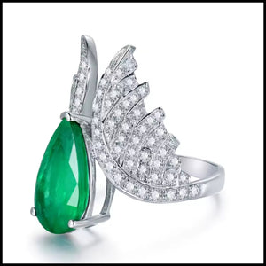 18k white gold ring with pear-shaped emerald and diamond angel wing design