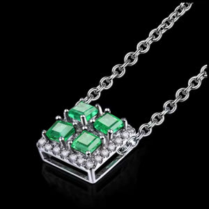 white gold necklace with green gemstones on a black background