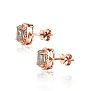 A pair of rose gold stud earrings with oval-cut clear gemstones and small accent stones, shown on a clean white background with a soft reflection below.