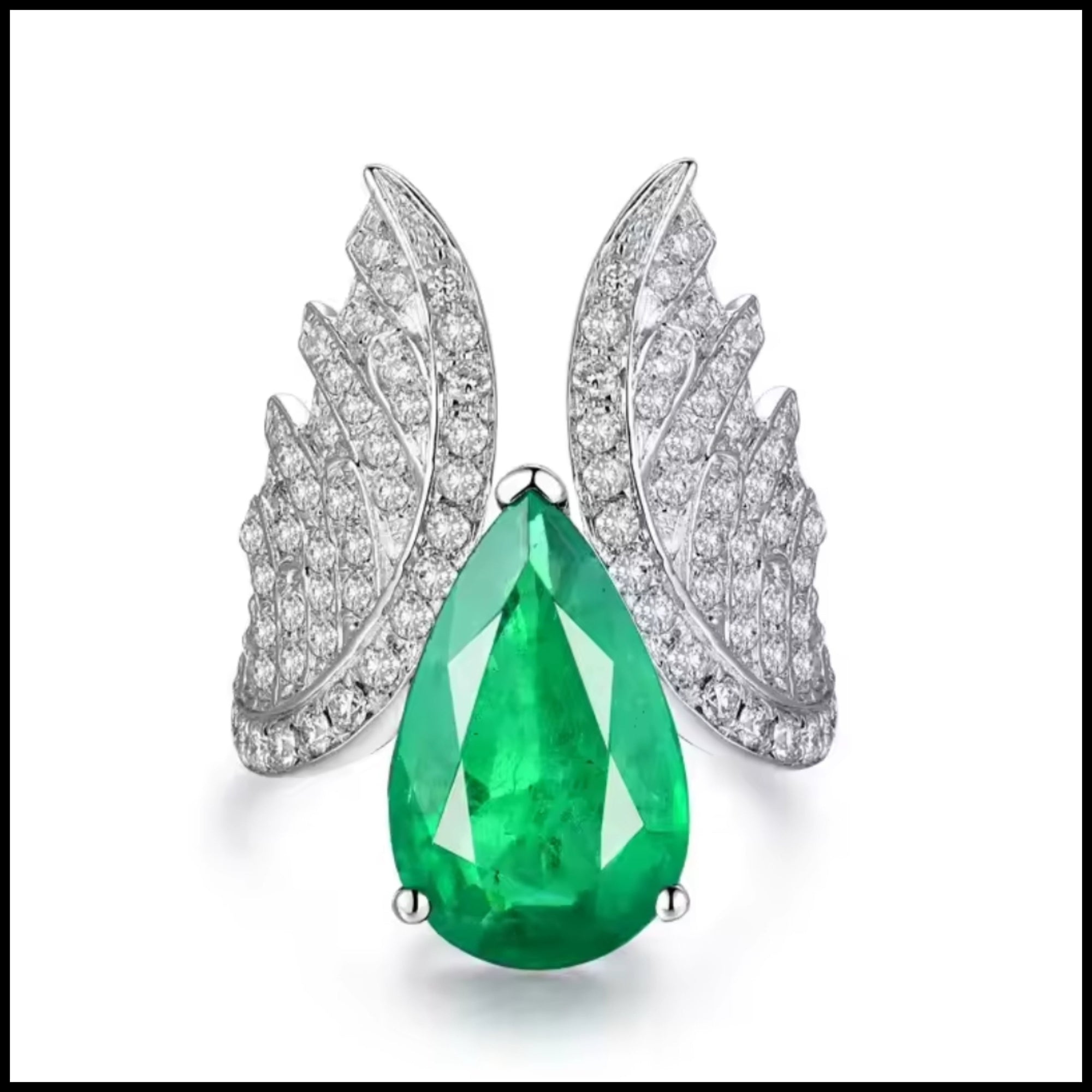 18k white gold ring with pear-shaped emerald and diamond angel wing design