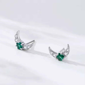 Pair of silver earrings with green gemstones on a white background