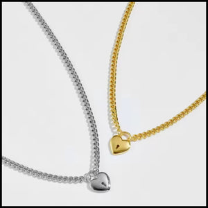 Two heart-shaped pendants on gold and silver chains against a white background