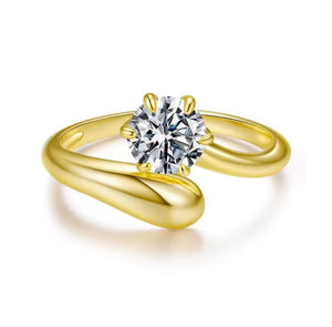A yellow gold ring with a twisted, open band design and a large round brilliant-cut diamond center stone, shown on a clean white background.