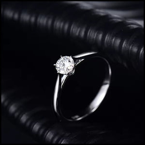 Silver ring with a diamond on a dark textured surface