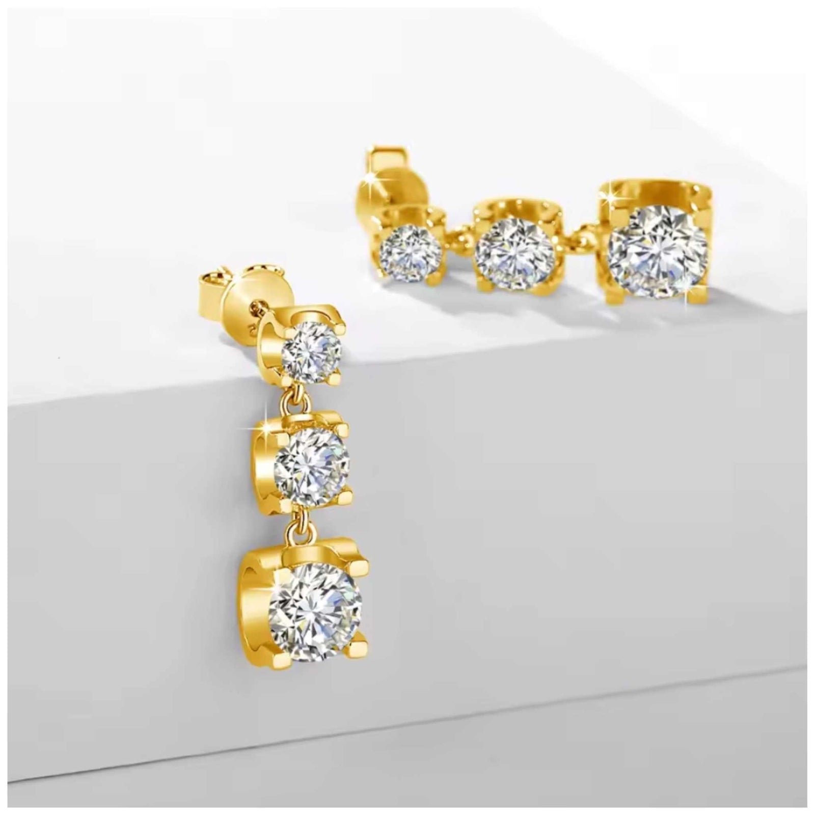 Three-stone moissanite drop earrings in yellow gold plated silver with 2.65 carats total brilliance