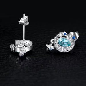 Silver earrings with a blue gemstone on a black background