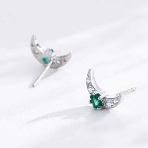 Silver earrings with green gemstones on a white background