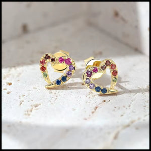 Heart-shaped earrings with colorful gemstones on a light background