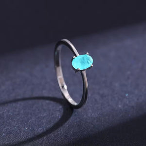 Silver ring with a turquoise gemstone on a dark background