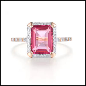 Ring with a pink gemstone and rose gold accents on a white background