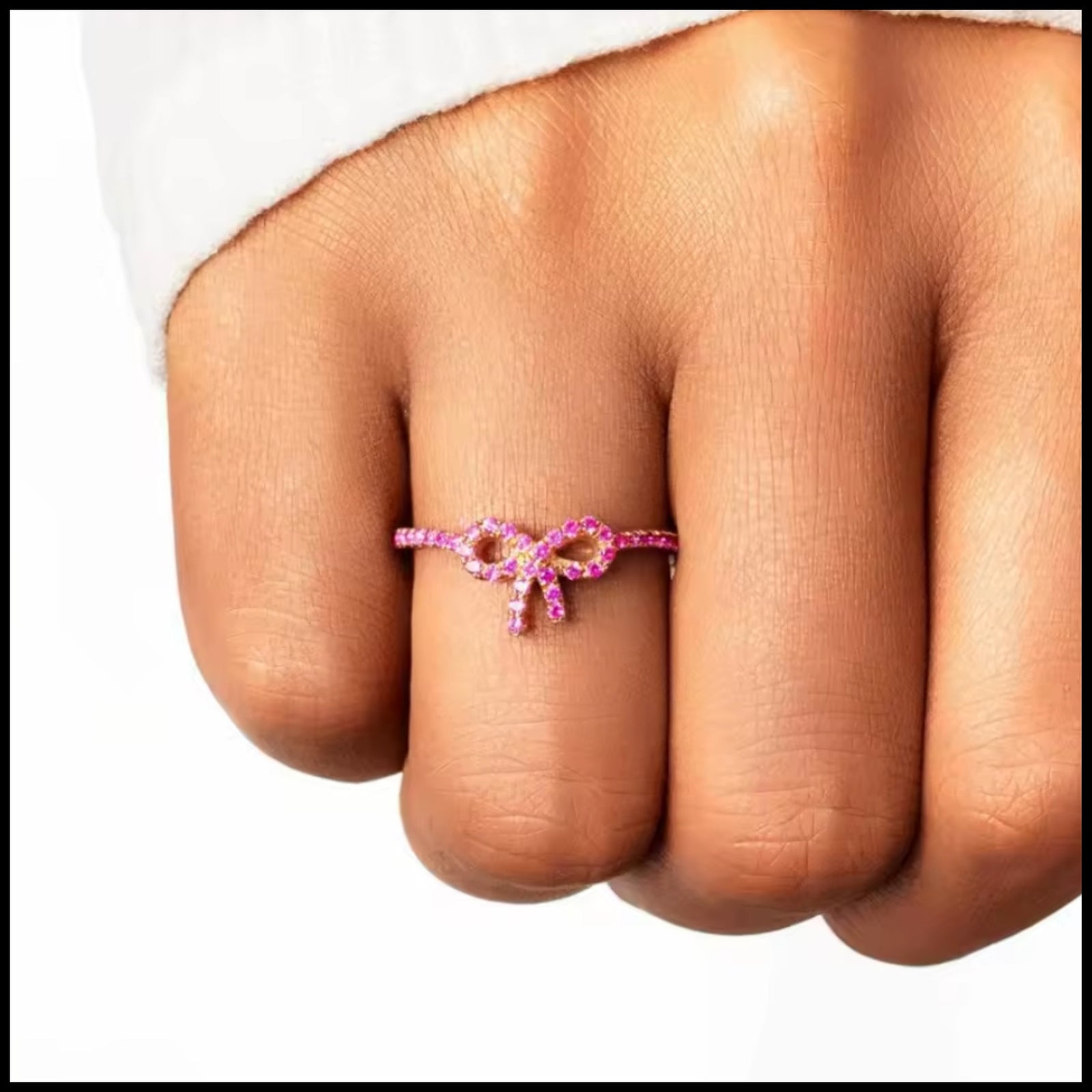 Pink zircon bow ring on finger with delicate gold-plated silver minimalist design