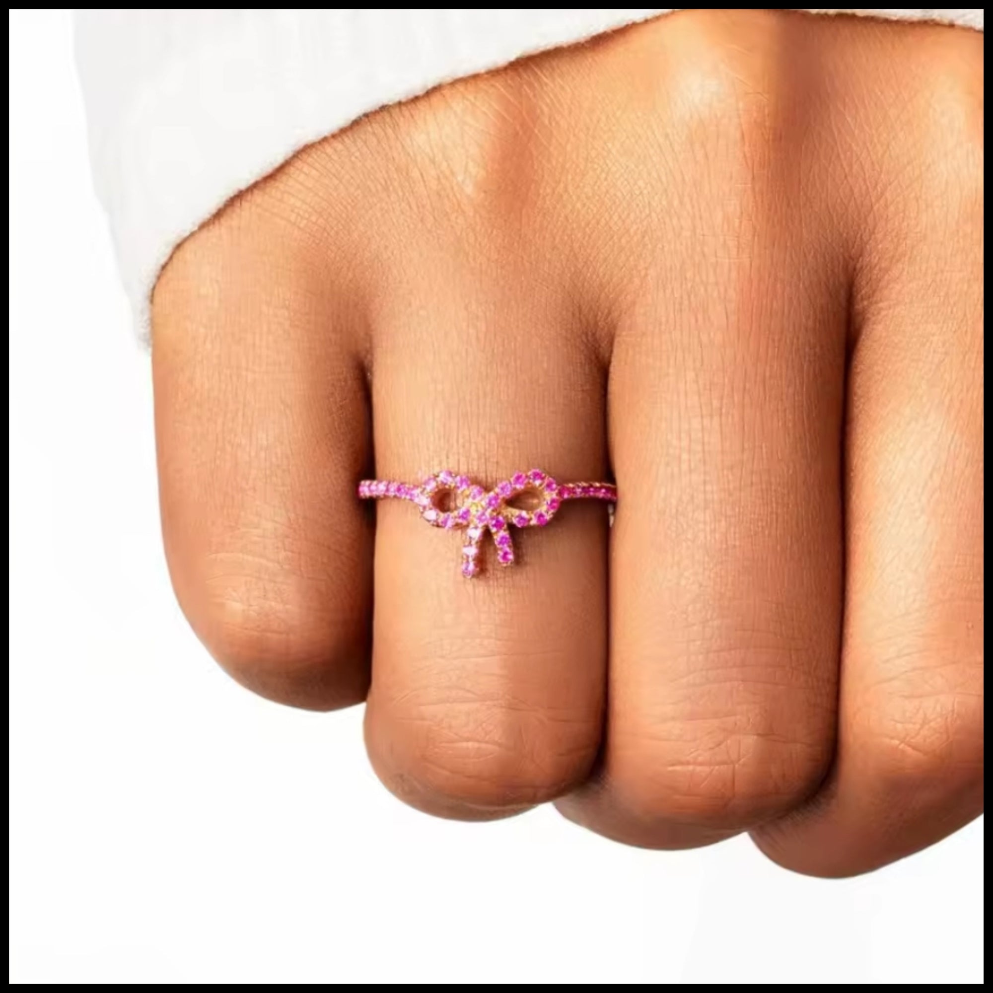 Pink zircon bow ring on finger with delicate gold-plated silver minimalist design