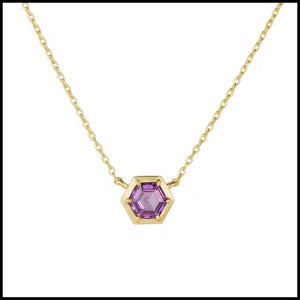 Gold necklace with a hexagonal purple gemstone on a white background