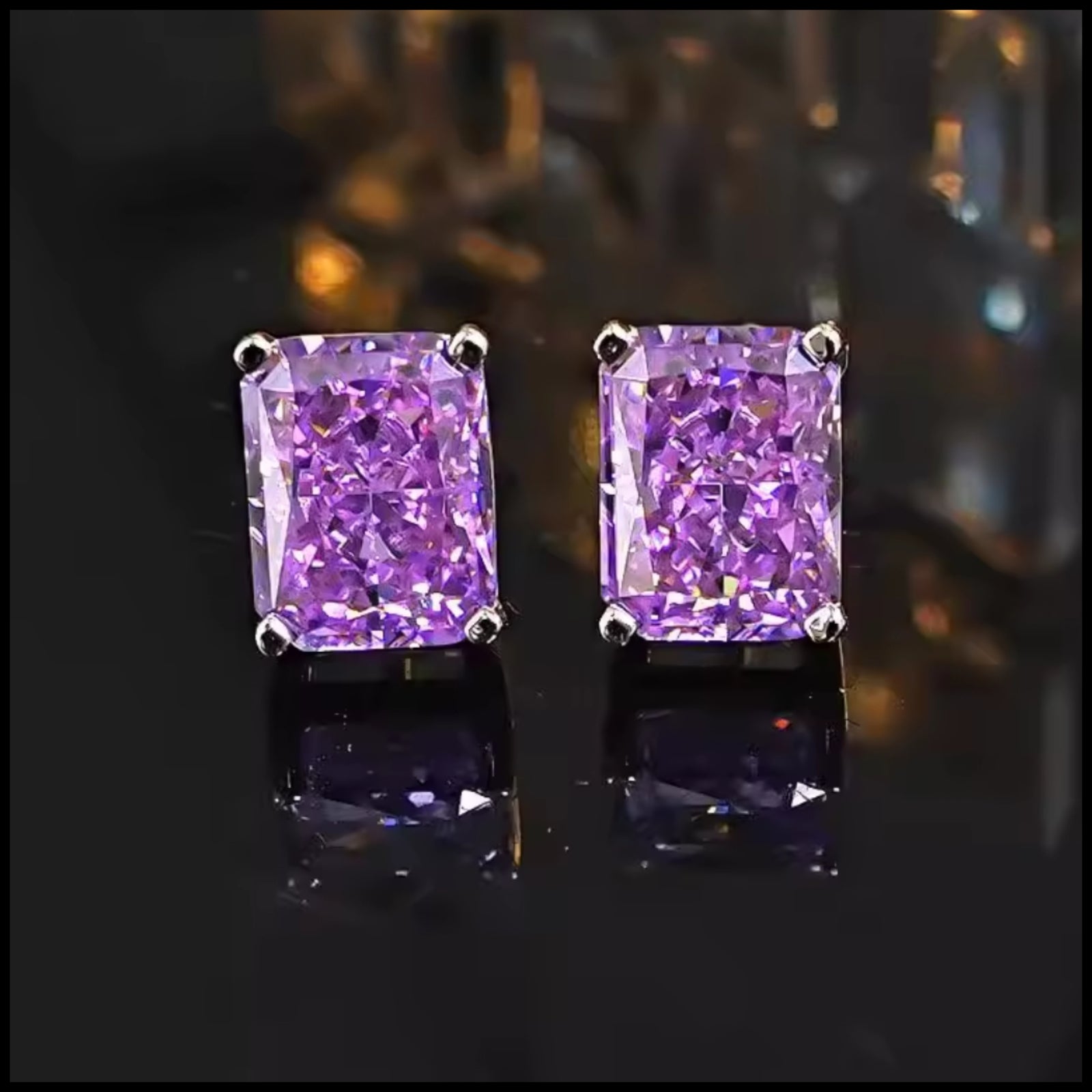 Purple gemstone stud earrings on a reflective surface with blurred background