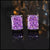 Purple gemstone stud earrings on a reflective surface with blurred background