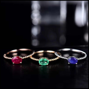Three rings with gemstones on a dark background