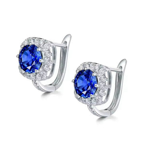 Sapphire Diamond 18K Gold earrings in polished white gold, with vivid blue sapphires framed by round diamonds in a square halo.