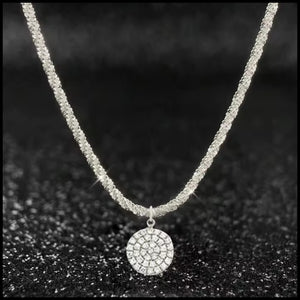 Necklace with a round, diamond-studded pendant on a dark textured background