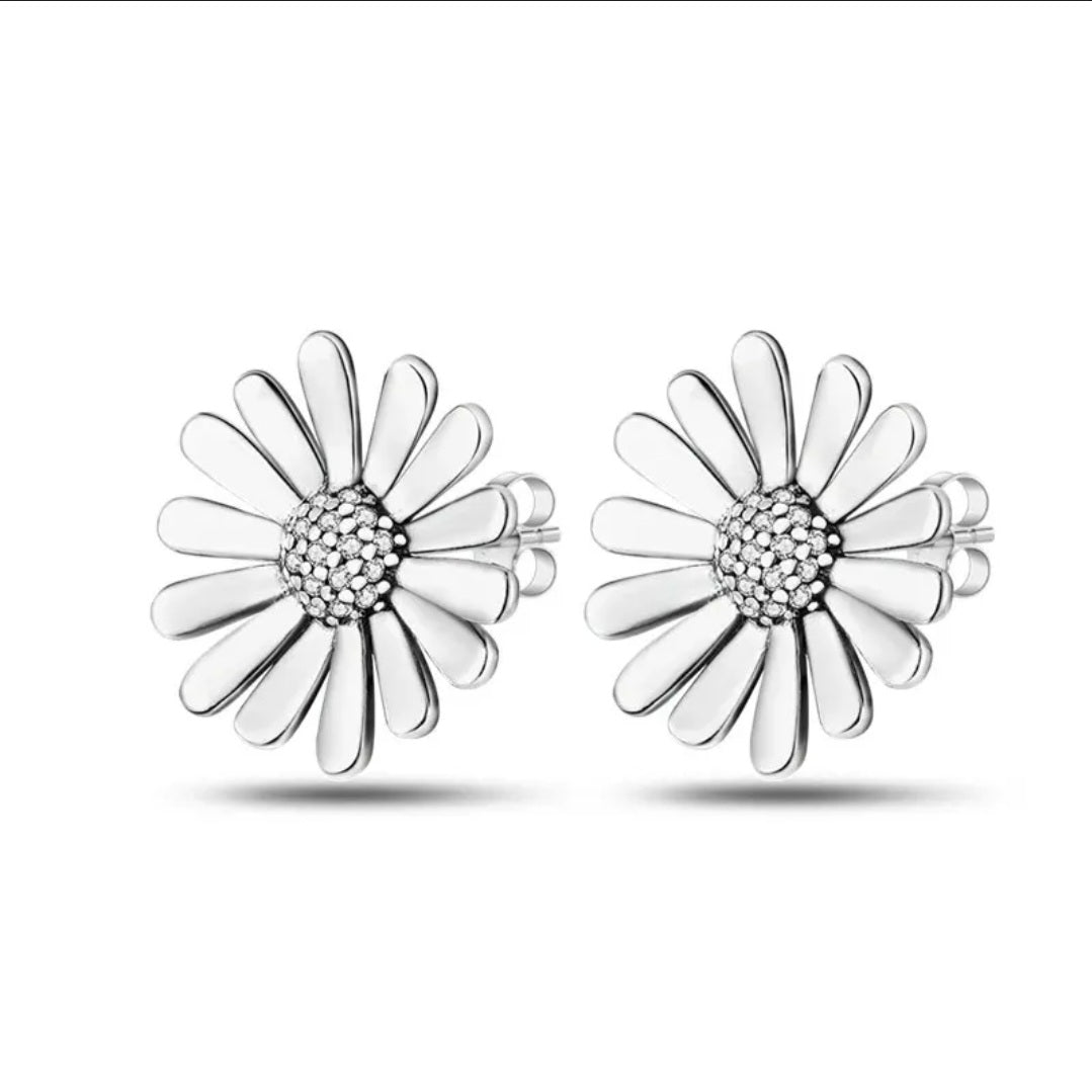 A pair of silver stud earrings designed in the shape of daisies, with a central sparkling stone surrounded by smaller ones.
