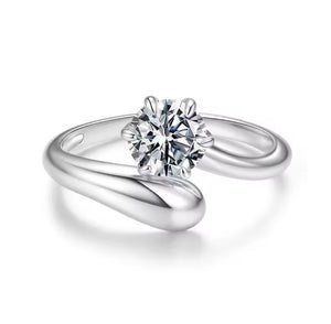 A silver solitaire engagement ring with a round brilliant-cut diamond center stone, set in a polished wrap-style band on a clean white background.