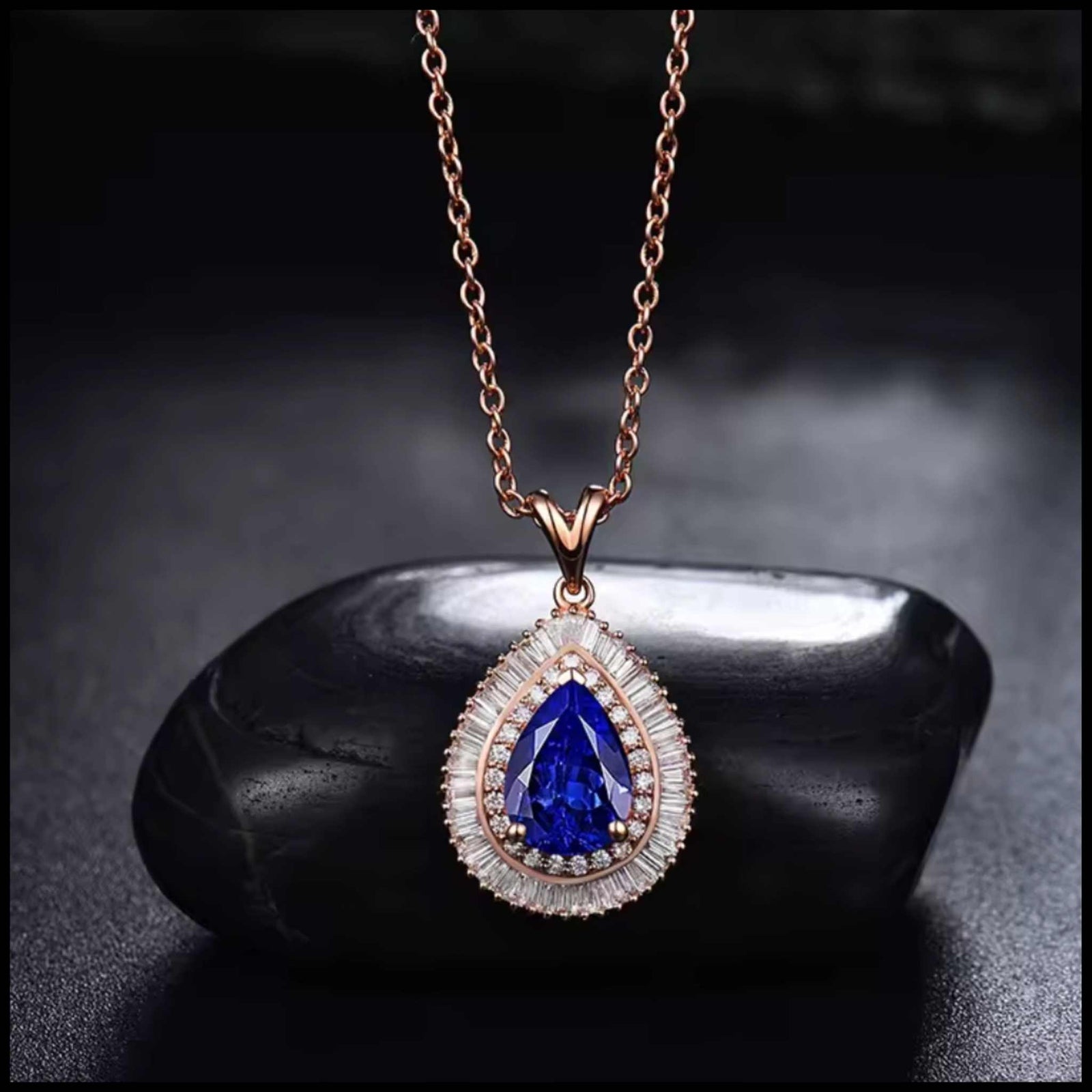 Elegant pear-shaped tanzanite diamond rose gold necklace on black stone background