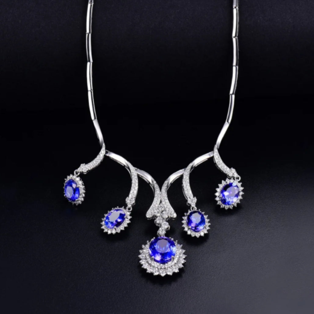 A luxurious necklace featuring solid 18K white gold, adorned with tanzanite gemstones and round cut natural diamonds.