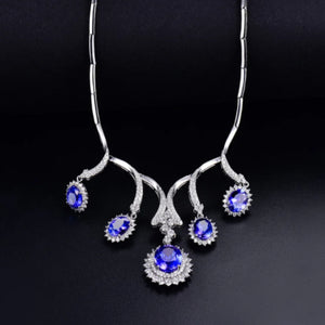 A luxurious necklace featuring solid 18K white gold, adorned with tanzanite gemstones and round cut natural diamonds.