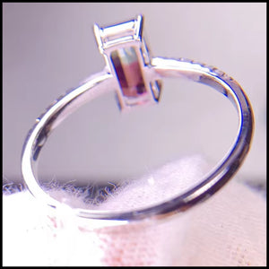 white gold ring with a diamond on a textured surface