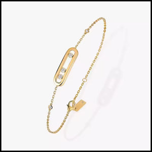Gold bracelet with a chain and decorative clasp on a white background