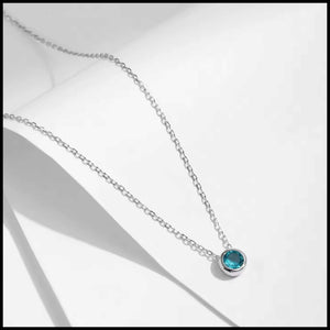 Necklace with a blue gemstone on a white background