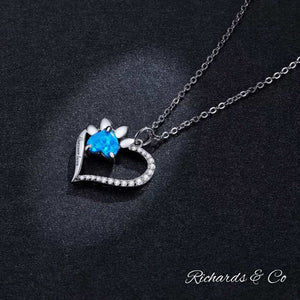 Heart-shaped silver necklace with blue zirconia and paw print pendant on link chain
