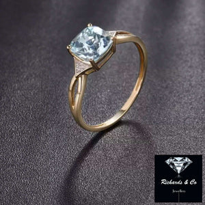 Blue Topaz & Diamond Ring in 14k yellow gold with cushion-cut blue topaz and six natural diamonds in prong setting