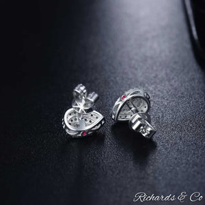 Diamond Pear Earrings in solid 14k white gold with natural round cut diamonds and pink sapphire side stones on black background