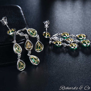 High end luxury earrings featuring natural emeralds and diamonds in 18K white gold chandelier design