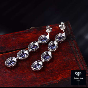 Elegant Tanzanite and Diamond Drop Earrings set in 14k white gold with oval tanzanite stones and round diamonds.