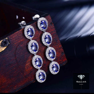 Elegant tanzanite and diamond drop earrings set in 14k white gold with oval cut tanzanite and round diamonds