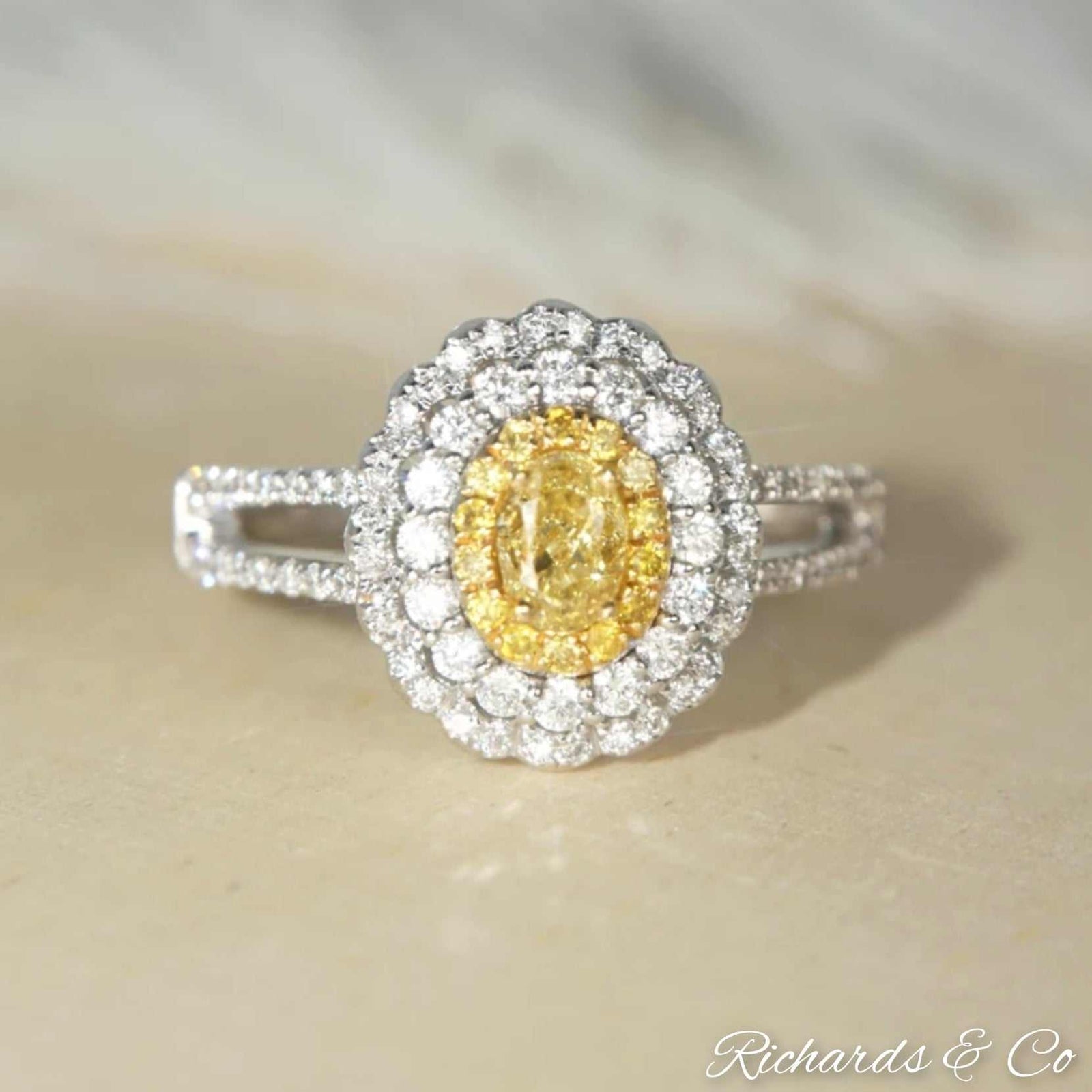 Yellow and white halo engagement diamond ring with oval yellow center diamond and white diamond halo in 18K white gold