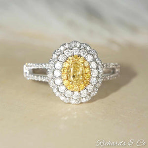 Yellow and white halo engagement diamond ring with oval yellow center diamond and white diamond halo in 18K white gold
