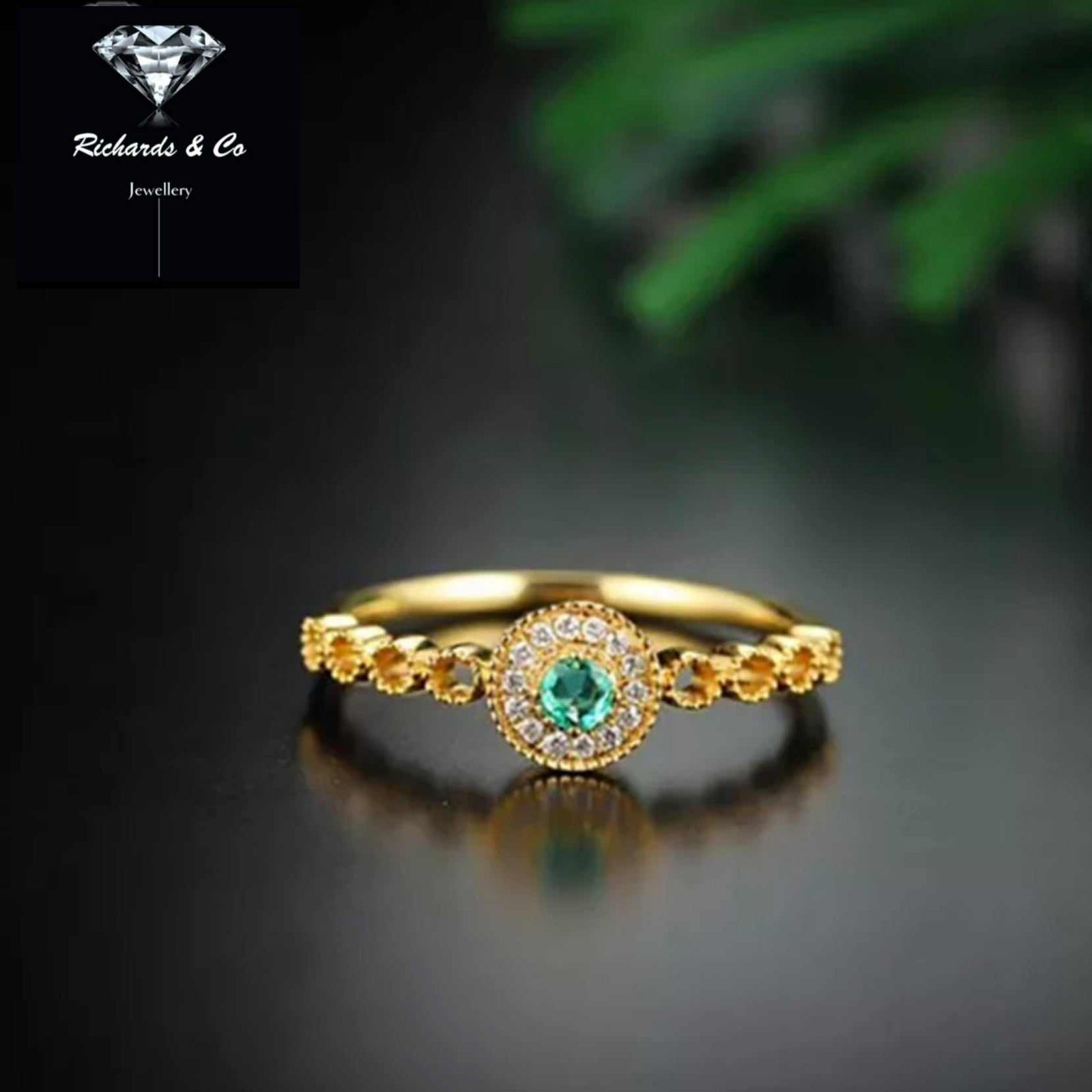 Elegant emerald and diamond ring set in 18k yellow gold with delicate band design