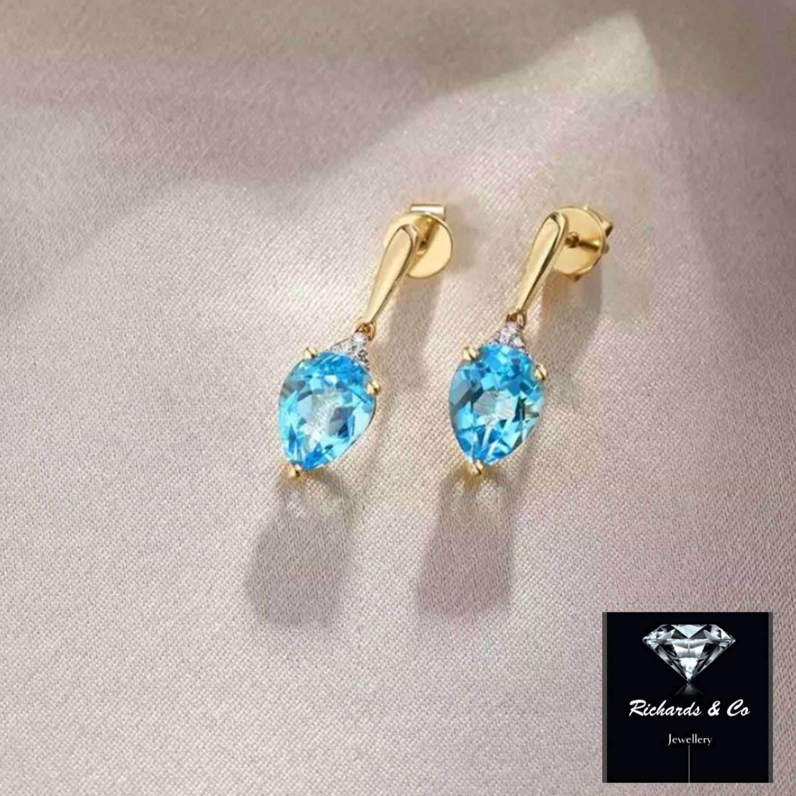 14K yellow gold earrings with pear-shaped Swiss blue topaz and round natural diamonds studs