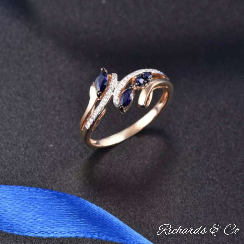 14K rose gold ring with marquise blue sapphires and round cut diamonds in prong setting