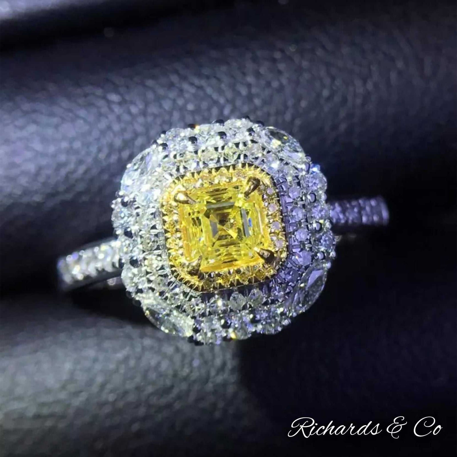 Rare yellow diamond cluster engagement ring in 18k white gold with cushion cut center stone and white diamond halo