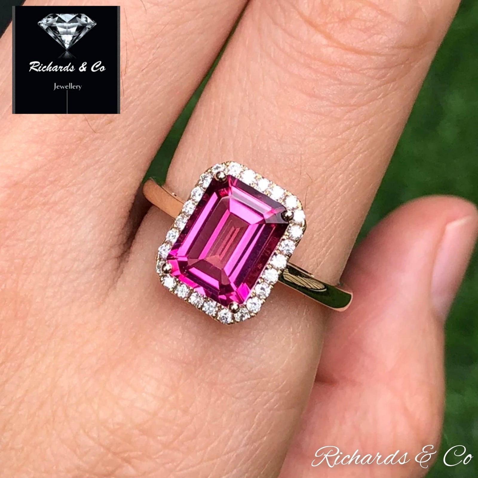 Emerald cut pink topaz ring with halo diamonds set in 14K yellow gold on finger